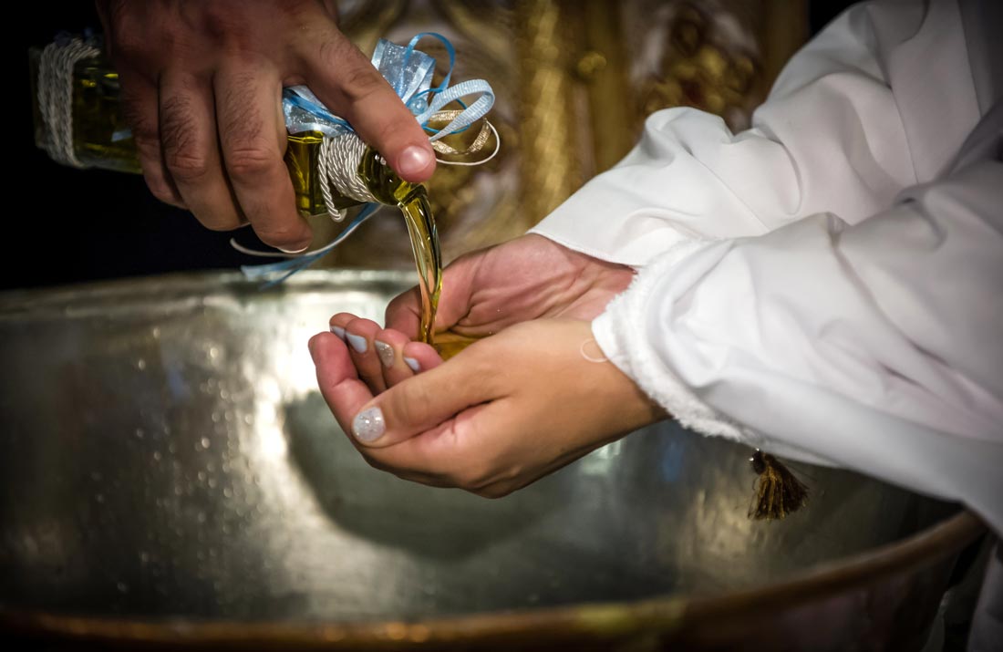 Χέρια νονάς που κρατούν το λάδι - Hands with baptism oil